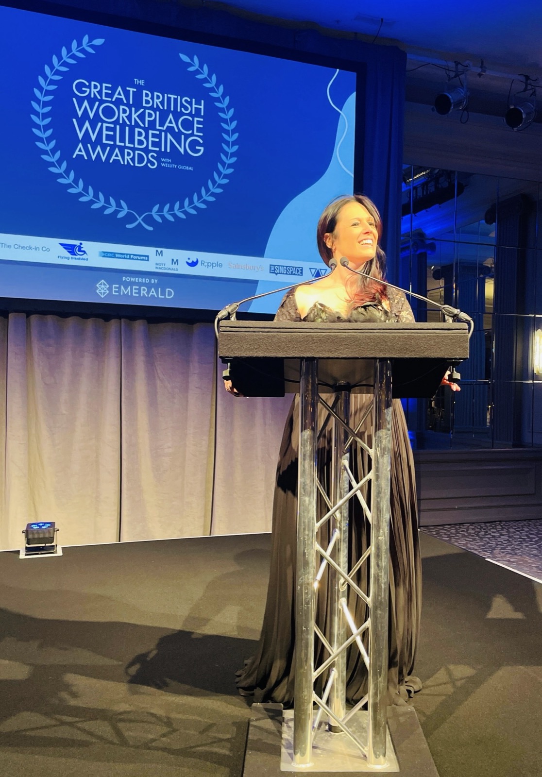 Sadie Restorick at the Great British Workplace Wellbeing Awards podium