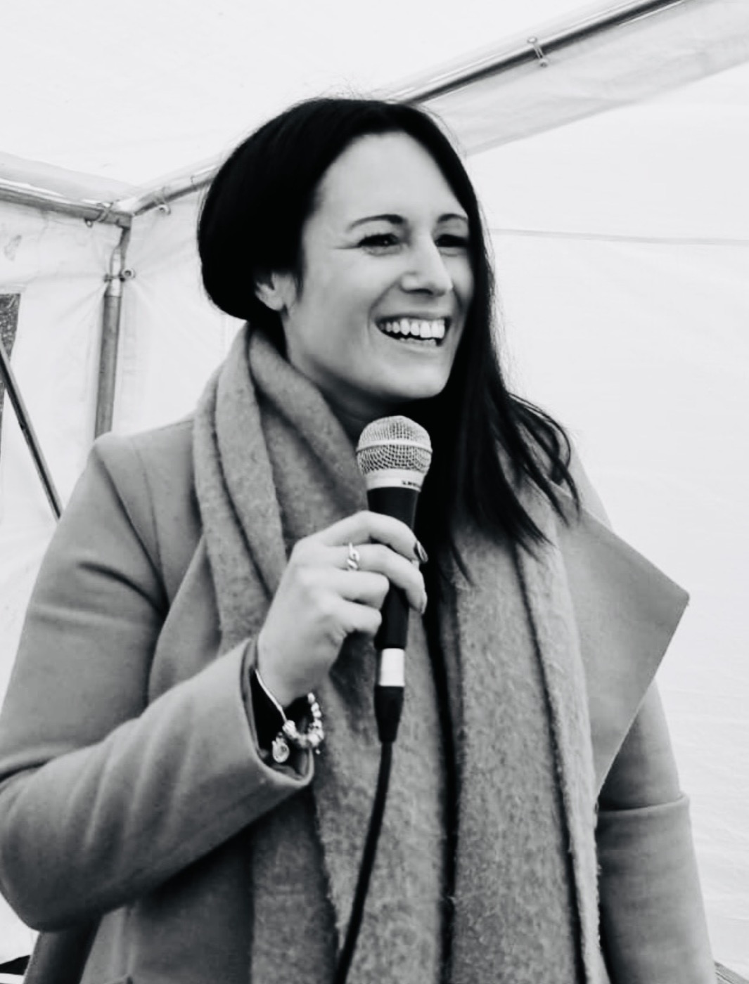 Sadie Restorick speaking at an event, holding a microphone